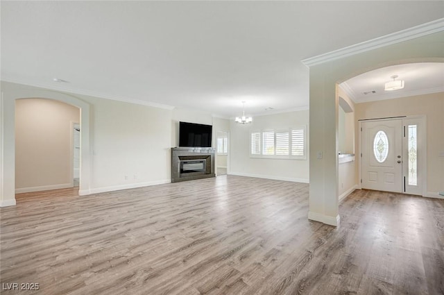 entrance foyer with light hardwood / wood-style flooring, ornamental molding, and a chandelier