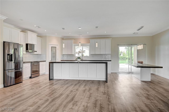 kitchen with a center island, crown molding, light wood-type flooring, appliances with stainless steel finishes, and white cabinets