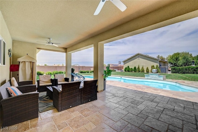 view of patio / terrace with ceiling fan, an outdoor living space, and a fenced in pool