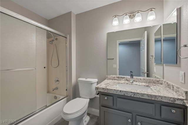 full bathroom featuring toilet, bath / shower combo with glass door, and vanity