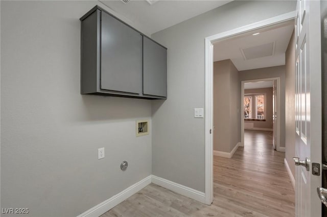 laundry room featuring washer hookup, cabinets, and light hardwood / wood-style flooring