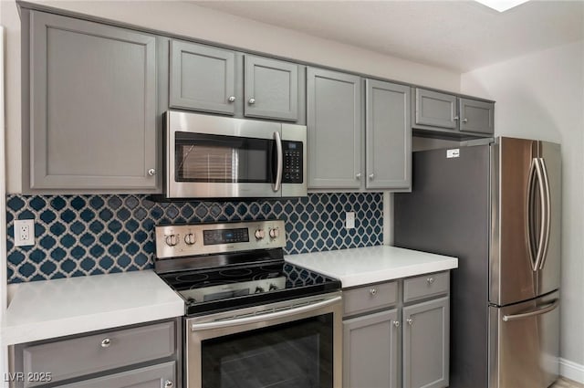 kitchen with tasteful backsplash, gray cabinetry, and stainless steel appliances