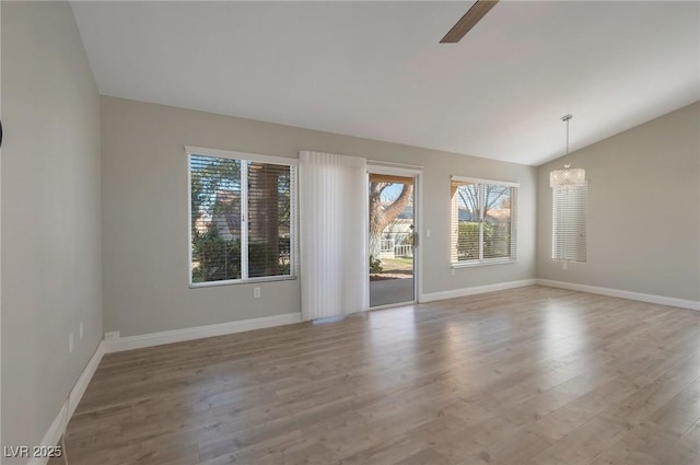 unfurnished room with lofted ceiling, ceiling fan with notable chandelier, and light hardwood / wood-style floors