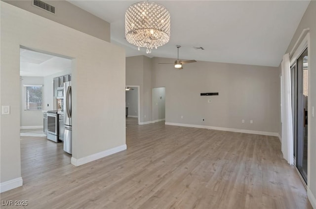 unfurnished living room featuring vaulted ceiling, ceiling fan with notable chandelier, and light hardwood / wood-style flooring