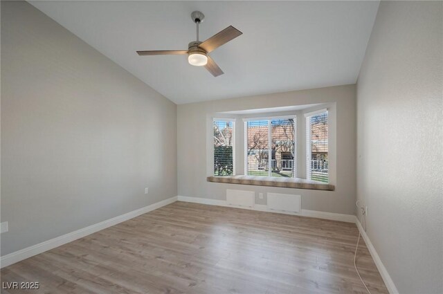 spare room with ceiling fan, lofted ceiling, and light wood-type flooring