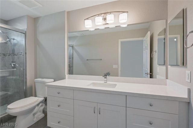 bathroom featuring a shower with shower door, toilet, and vanity