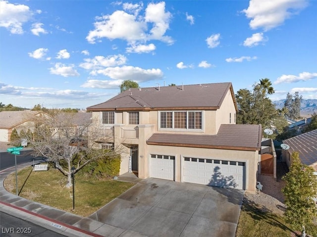 front of property with a front lawn, a balcony, and a garage