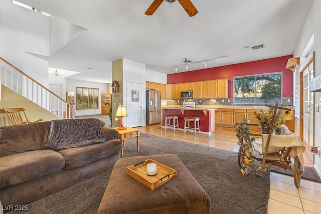 living room with ceiling fan and sink