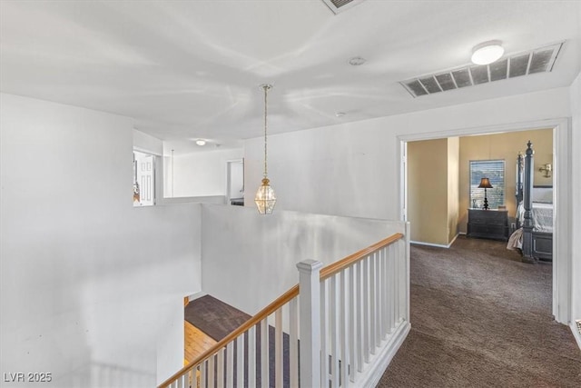 hallway with dark colored carpet