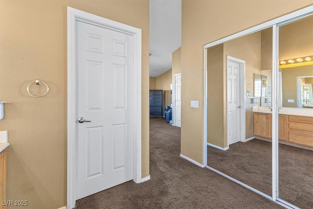 hallway featuring dark carpet and lofted ceiling