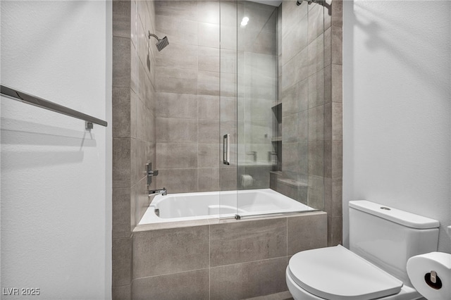 bathroom with toilet and bath / shower combo with glass door