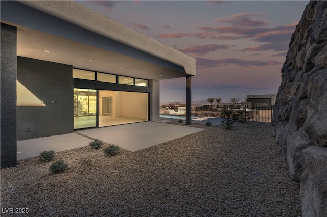 back house at dusk with a patio