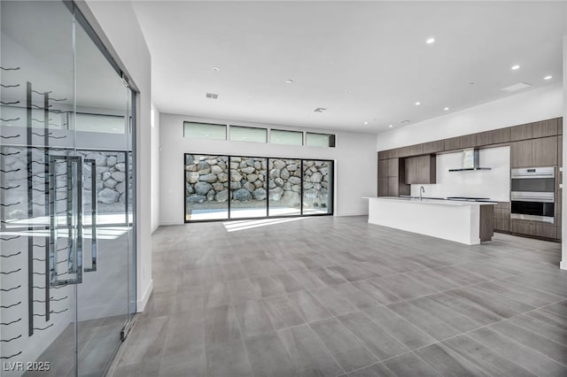 unfurnished living room with plenty of natural light and sink