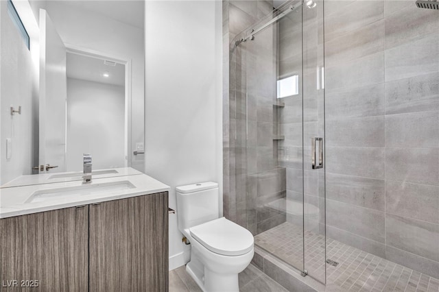 bathroom with vanity, toilet, and a shower with door