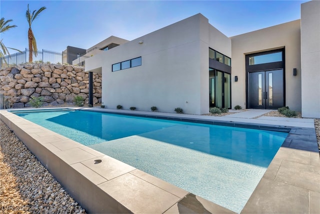 view of swimming pool featuring french doors