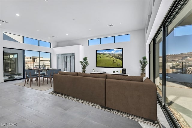 living room with a towering ceiling and a healthy amount of sunlight