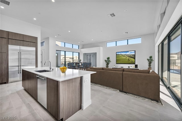 kitchen with a kitchen island with sink, sink, plenty of natural light, and stainless steel appliances