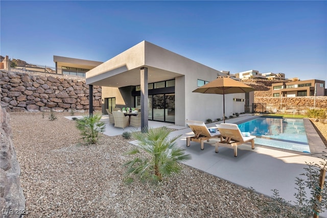 back of house with a fenced in pool and a patio area