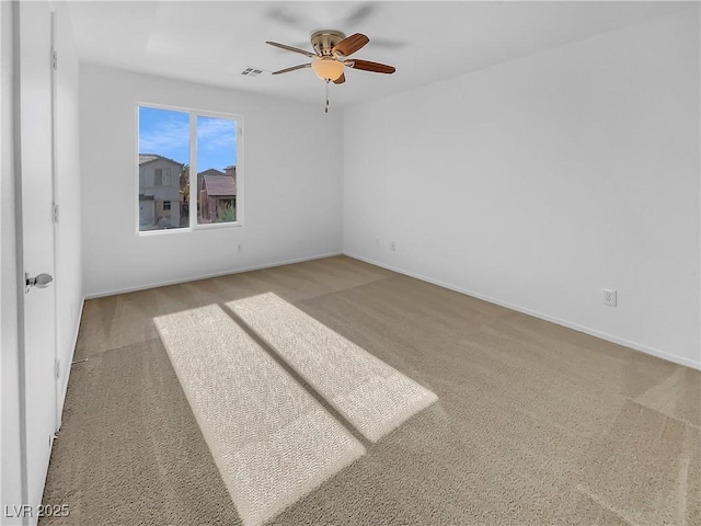 empty room featuring ceiling fan and light colored carpet