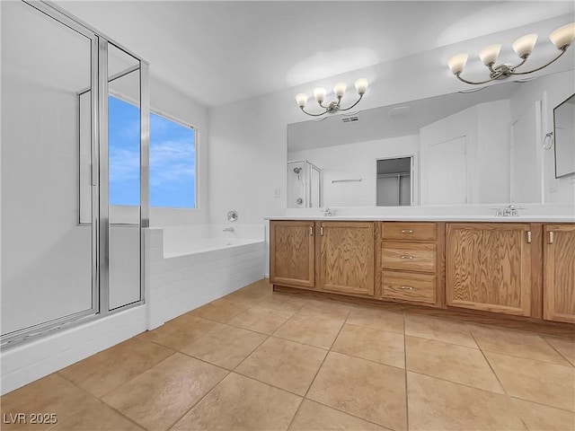 bathroom with tile patterned flooring, shower with separate bathtub, a notable chandelier, and vanity