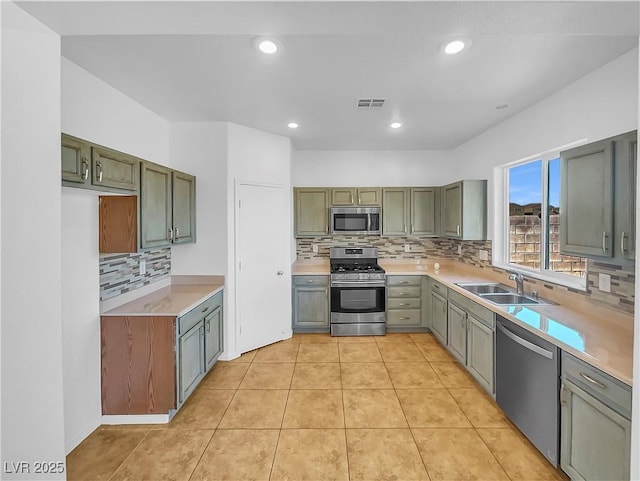 kitchen featuring decorative backsplash, sink, stainless steel appliances, and light tile patterned flooring