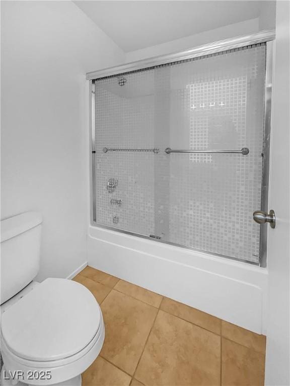 bathroom with tile patterned floors, toilet, and combined bath / shower with glass door