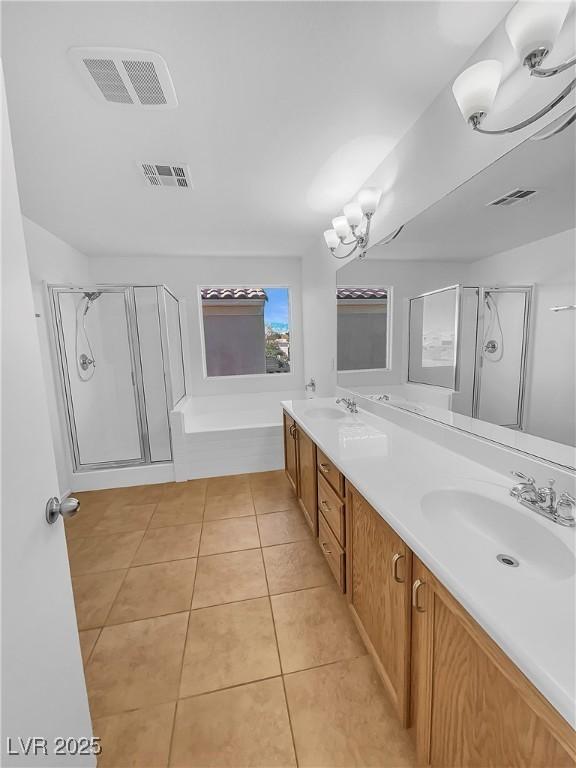 bathroom with tile patterned floors, vanity, an inviting chandelier, and plus walk in shower