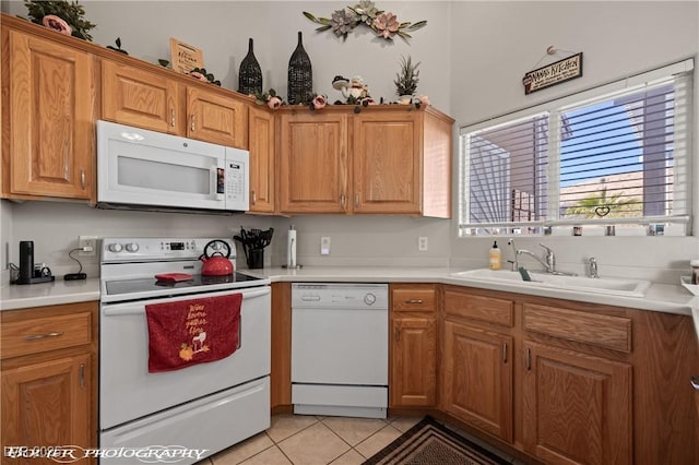 kitchen with light tile patterned floors, sink, and white appliances