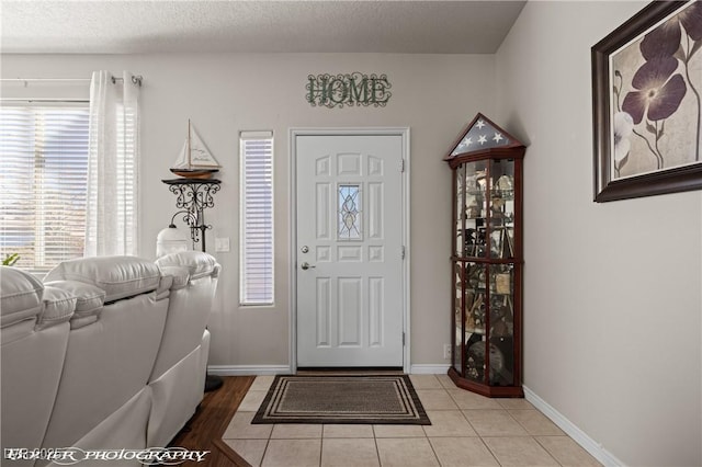 entrance foyer with a textured ceiling and light tile patterned floors