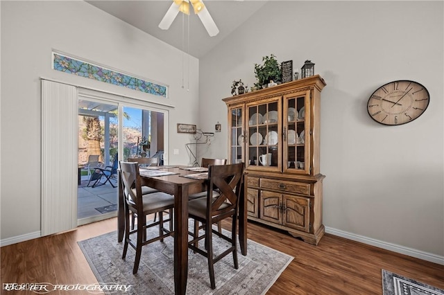 dining area with ceiling fan, dark wood-type flooring, and lofted ceiling