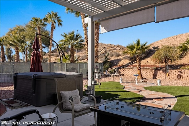 view of patio with a mountain view, a hot tub, and a pergola