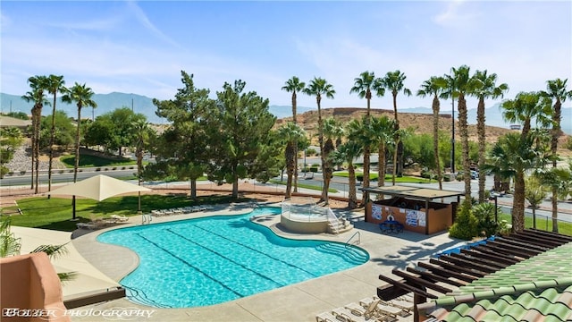 view of swimming pool with an outdoor bar, a patio area, and a mountain view