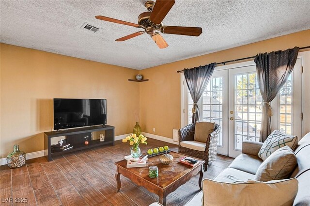 living room featuring ceiling fan, a textured ceiling, and french doors