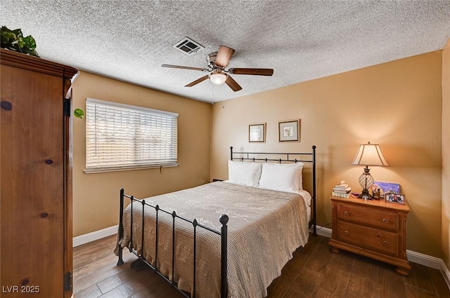 bedroom with ceiling fan, a textured ceiling, and dark hardwood / wood-style flooring