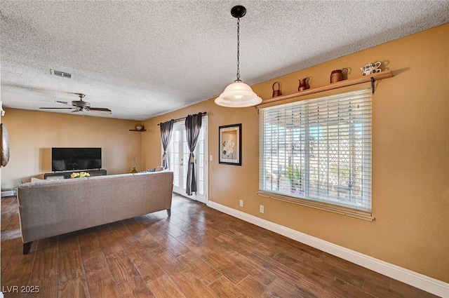 living room with hardwood / wood-style flooring, a textured ceiling, and ceiling fan