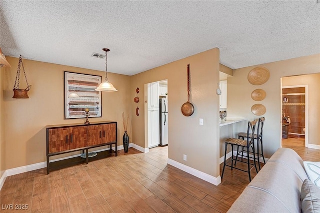 interior space featuring a textured ceiling and light wood-type flooring