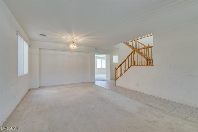 spare room with light tile patterned floors and a notable chandelier