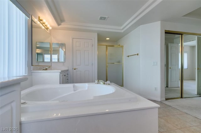 bathroom featuring plus walk in shower, tile patterned floors, a raised ceiling, and vanity