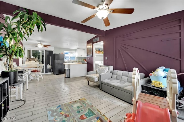 living room with ceiling fan and sink