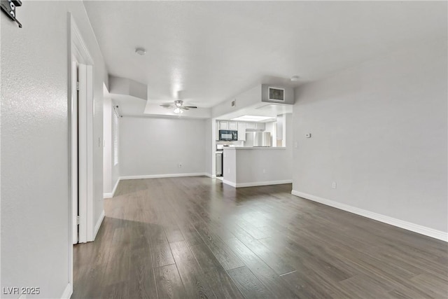 unfurnished living room featuring ceiling fan and dark hardwood / wood-style flooring