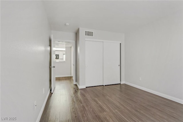 unfurnished bedroom featuring a closet and wood-type flooring