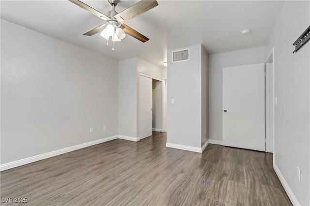 unfurnished room with ceiling fan and dark wood-type flooring