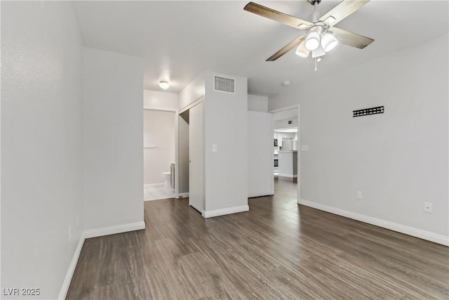 empty room with ceiling fan and dark hardwood / wood-style flooring