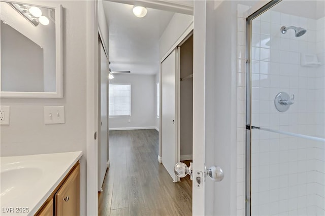 bathroom featuring vanity, wood-type flooring, and a shower with door