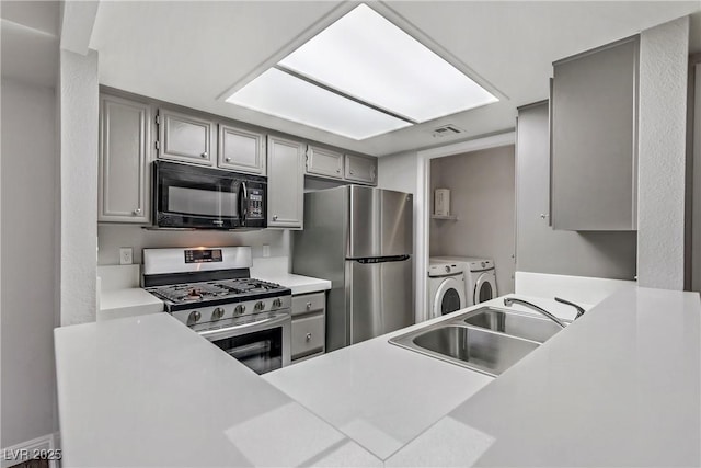 kitchen featuring separate washer and dryer, sink, gray cabinetry, and stainless steel appliances