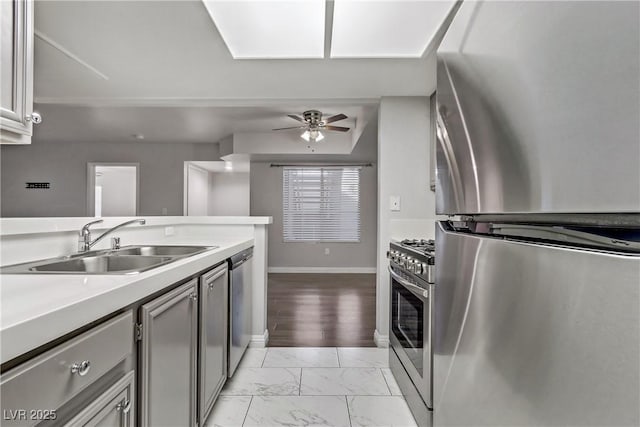 kitchen featuring ceiling fan, sink, appliances with stainless steel finishes, and gray cabinetry