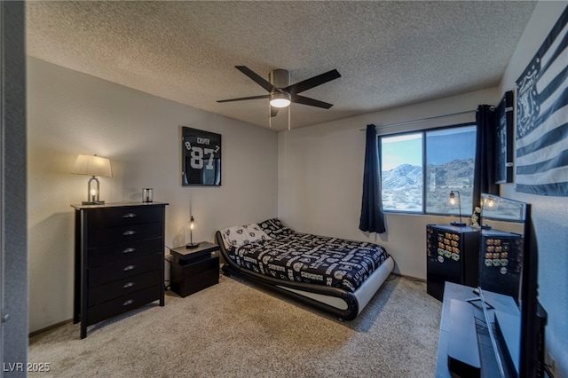 bedroom featuring ceiling fan, a textured ceiling, and light carpet