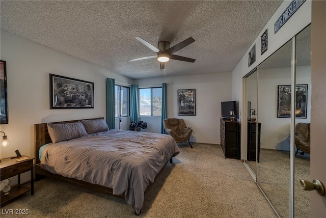 bedroom featuring ceiling fan, a closet, light carpet, and a textured ceiling