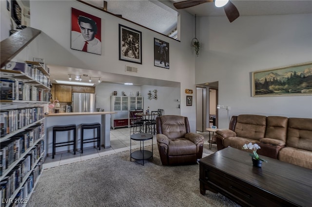 living room with high vaulted ceiling, light tile patterned floors, and ceiling fan