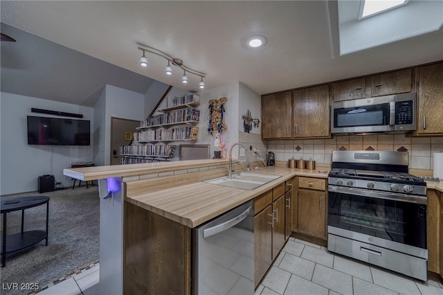 kitchen featuring kitchen peninsula, appliances with stainless steel finishes, and sink